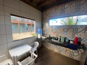 a small bathroom with a bench and a window at Suítes Taipu de Fora in Marau