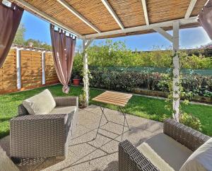 a patio with chairs and a table and a pergola at Sea Love in Olbia