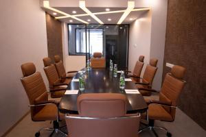 a conference room with a long table and chairs at Hema's Hotel Supreme in Visakhapatnam