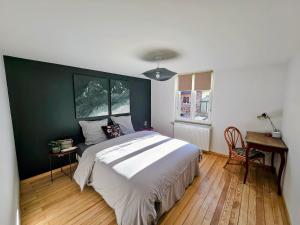 a bedroom with a bed and a green wall at Appartement Le petit Bretzel in Neuwiller-lès-Saverne