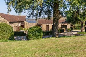 a house with a tree in a yard at La Ferme de la Croix d'Allon in Sarlat-la-Canéda