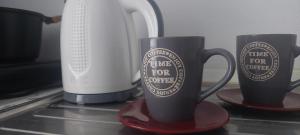 two coffee cups on a counter next to a blender at Castello Azzurro in Agia Anna Naxos +5 photos