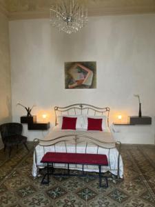 a bedroom with a bed with red pillows and a chandelier at Palazzo Cariddi Apartment in Nardò