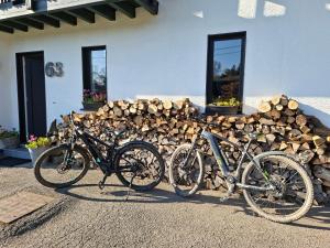 two bikes parked in front of a pile of logs at Aux Capucines in Theux