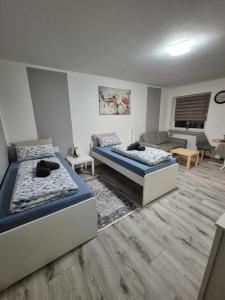 a bedroom with two beds and a living room at Apartment an der Weser in Bremerhaven