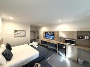 a hotel room with a bed and a tv at Katherine Motel in Katherine