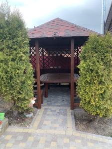 a wooden gazebo with a bench in the middle at Апартаменти Studio Amur Creative in Khmelnytskyi