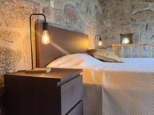 a bedroom with a bed and two lights on a table at Serena Nest 03 in Rio Douro