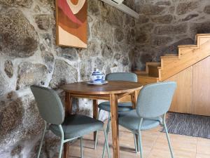 a wooden table with four chairs and a vase on it at Serena Nest 03 in Rio Douro