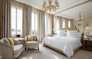 a bedroom with a bed and a chair and a chandelier at Danieli, Venezia, A Four Seasons Hotel in Venice