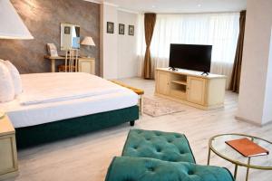 a bedroom with a bed and a tv and a chair at Hotel Paradis in Cluj-Napoca