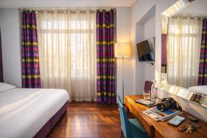 a hotel room with a bed and a desk with a mirror at Rivage Hotel Restaurant Lutry in Lausanne