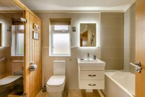 a bathroom with a toilet and a sink and a tub at Primrose 2 bed - Violet in Eye +17 photos