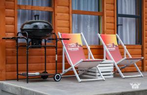 two lounge chairs and a grill on a porch at Domek 57m2 - max 5 osób - NR4 in Ciężkowice