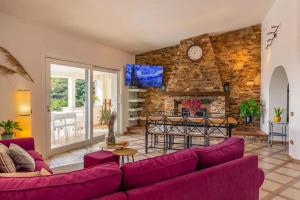 a living room with purple furniture and a brick wall at Villa Terrazza sul Mare in Budoni