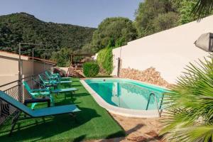 a swimming pool with lounge chairs next to a building at Villa Terrazza sul Mare in Budoni