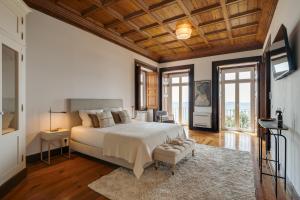 a bedroom with a large bed with a wooden ceiling at Blissful Seafront in Cascais +44 photos