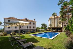 a backyard with a swimming pool and a house at Blissful Seafront in Cascais