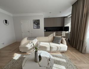 a living room with a couch and a table at City Centre Apartment with Cathedral View, Self Check-in in Šiauliai
