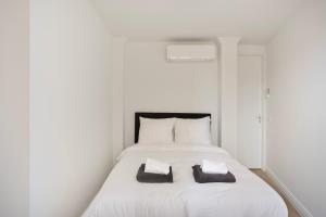a white bed with two towels on top of it at Eindhoven City Suites Hoogstraat B 4P in Eindhoven