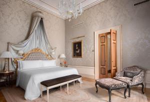a bedroom with a bed and a chair and a chandelier at Danieli, Venezia, A Four Seasons Hotel in Venice +10 photos