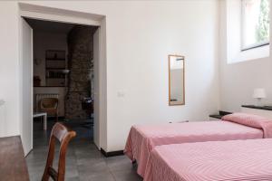 1 Schlafzimmer mit 2 Betten, einem Tisch und Stühlen in der Unterkunft Casa degli Archi in Levanto