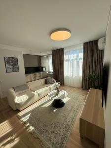 a living room with a couch and a table at City Centre Apartment with Cathedral View, Self Check-in in Šiauliai