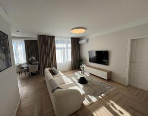 a living room with a couch and a flat screen tv at City Centre Apartment with Cathedral View, Self Check-in in Šiauliai
