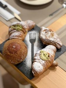 a plate with three types of bread and a fork at Etna Vibes Home in Catania