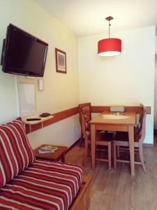 a living room with a couch and a table at Au coeur de l'Ariège in Ax-les-Thermes +4 photos
