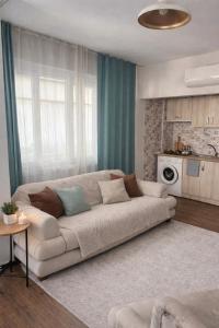 a living room with a couch and a kitchen at Soydan World Travel in Antalya