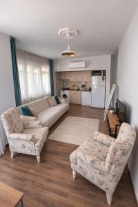 a living room with a couch and two chairs at Soydan World Travel in Antalya