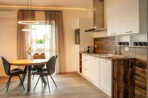 a kitchen with a table and chairs and a kitchen with white cabinets at Luxuriöse, 1-2-Zimmer-Apartments 30-55 qm in Fürstenau