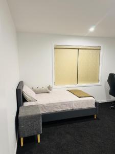 a bedroom with a bed and a window at TheQuietPadRest Easy Fly Easy in Christchurch