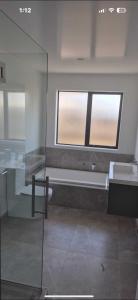 a bathroom with two sinks and a window at TheQuietPadRest Easy Fly Easy in Christchurch