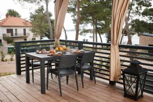 a table and chairs on a deck with food on it at Luxury Homes Pašman in Pašman