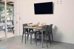 a dining room with a table and chairs and a tv at Luxury Homes Pašman in Pašman