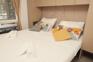 a white bed with pillows on top of it at Luxury Homes Pašman in Pašman