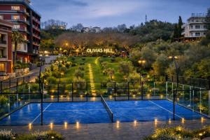 a tennis court in a park at night at Padel Olivia's Hill Resort in Durrës