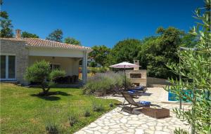 a backyard with chairs and an umbrella and a pool at Villa Hemera - Oasis of Peace and Privacy by Istrabook in Kršan