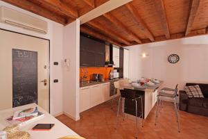 a kitchen and living room with a table and chairs at Borgo Del Torchio - Gardagate in Manerba del Garda +12 photos