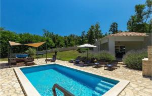 a swimming pool with chairs and umbrellas next to a house at Villa Hemera - Oasis of Peace and Privacy by Istrabook in Kršan