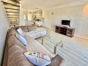a living room with a couch and a tv at 8 Settler Sands Ocean View in Port Alfred