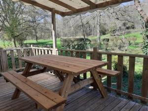 a wooden picnic table on a wooden deck at Mobil-home Moon River in Thiviers +10 photos