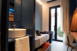 a bathroom with a sink and a bed in a room at La 15 Palmera Residence By Soho Boutique in Seville