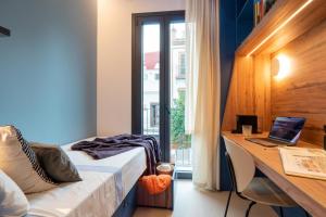 a bedroom with a bed and a desk with a laptop at La 15 Palmera Residence By Soho Boutique in Seville
