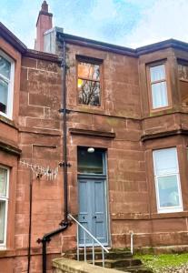 an old brick building with a blue door at Montford Shore in Rothesay