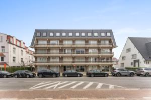 a tall building with cars parked in front of it at Lilyta B201 in De Haan