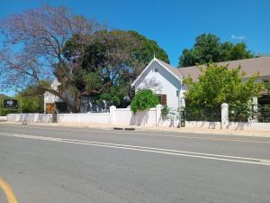 a white house on the side of a street at The Barn On 62 - Cottages in Montagu