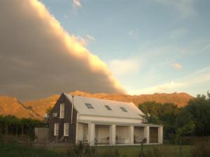 a house in front of a mountain with a rainbow at The Barn On 62 - Cottages in Montagu